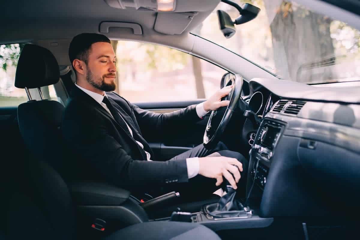 Chauffeur waiting beside a luxury vehicle